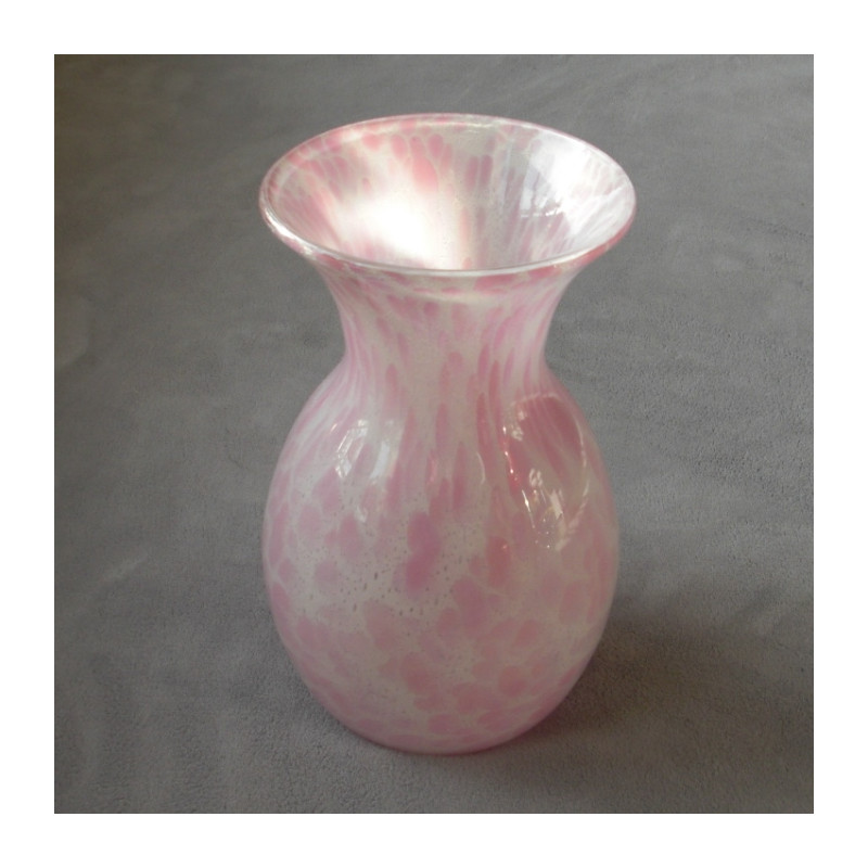 Un vase en verre contenant des bulles, de couleur rose de forme ronde.
